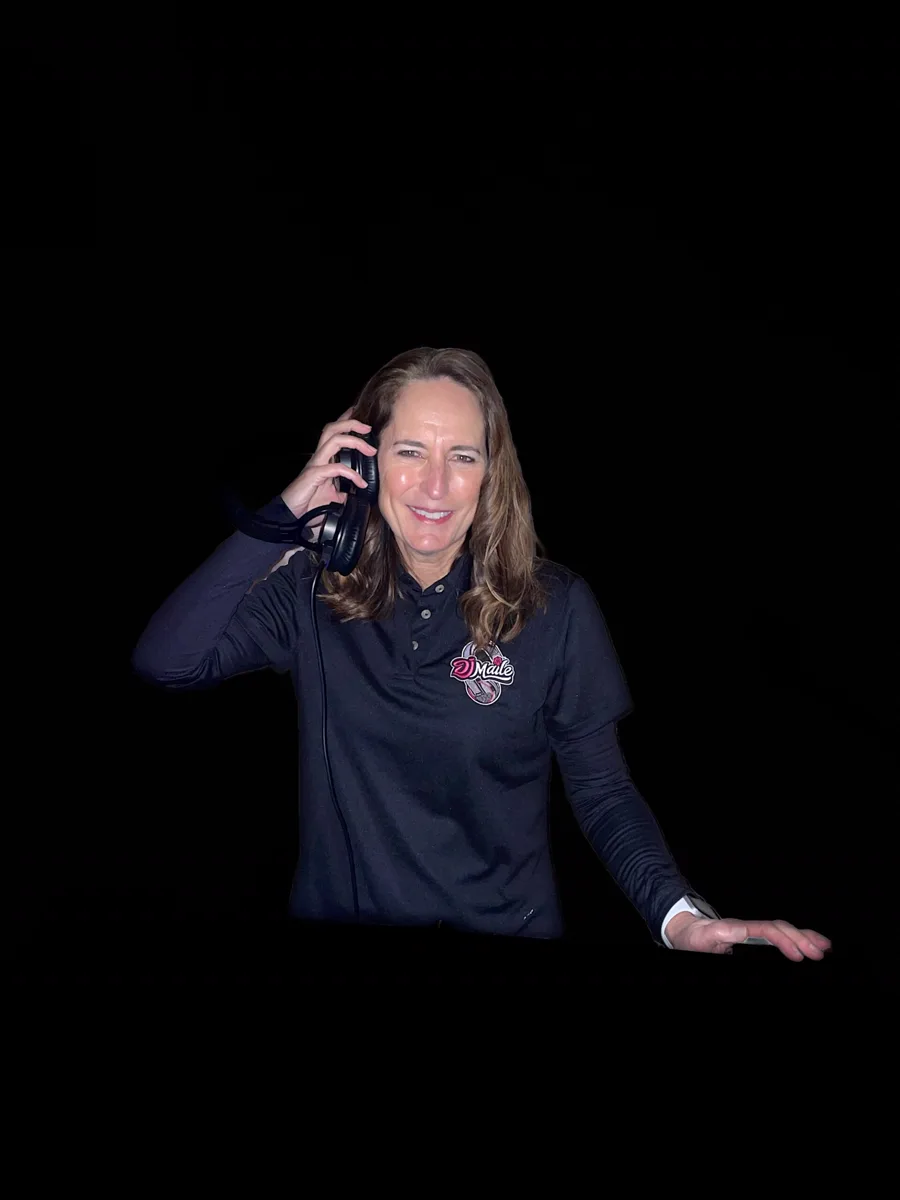 Kristy, aka DJ Maile, smiling with her headphones against a black background